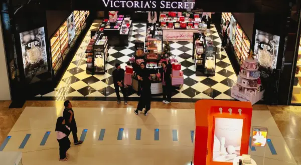 Sklep Victoria's Secret z mgiełkami i perfumami, z czarno-białą szachownicą na podłodze.